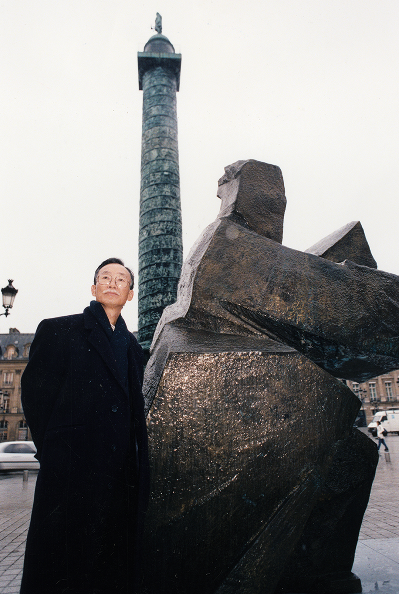 朱銘在1980年後發展出屬於自己的藝術風格，作品走向國際。圖為1997年朱銘在法國梵登廣場前與自己的作品合影。（圖片來源：朱銘美術館facebook）