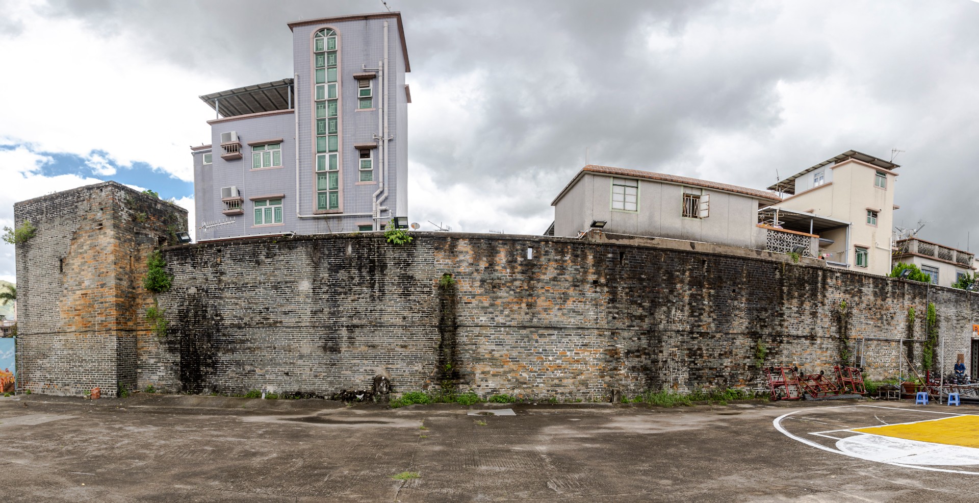 錦田吉慶圍外籃球場位置的一列城牆，左方更樓一堆紅磗是1899英軍炮轟倒塌後留下的修補痕跡，足見當日錦田鄉民抗英戰況的激烈。