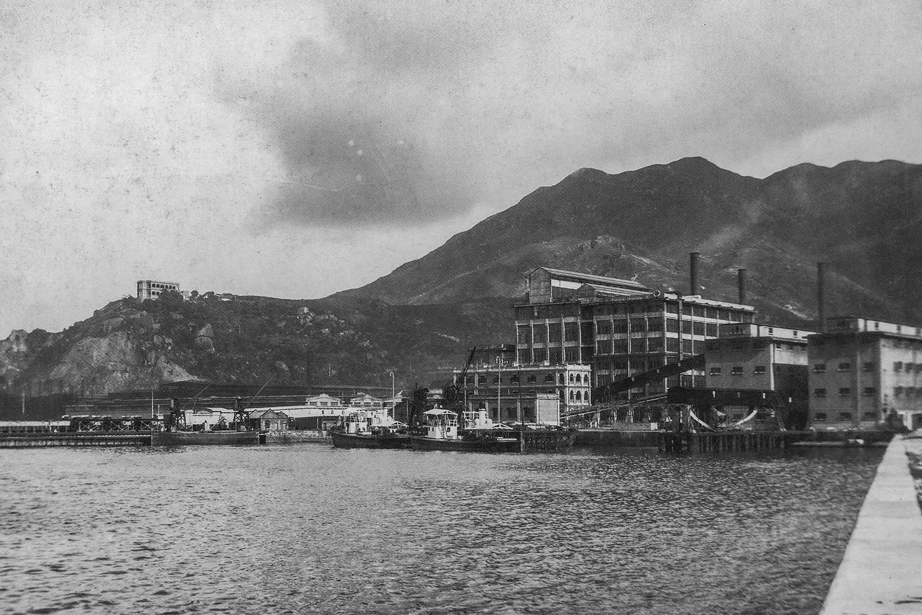 1880年代在鰂魚涌開設的太古糖廠，左邊為太古船塢及康山，約攝於1935年。（圖片來源：鄭寶鴻提供）